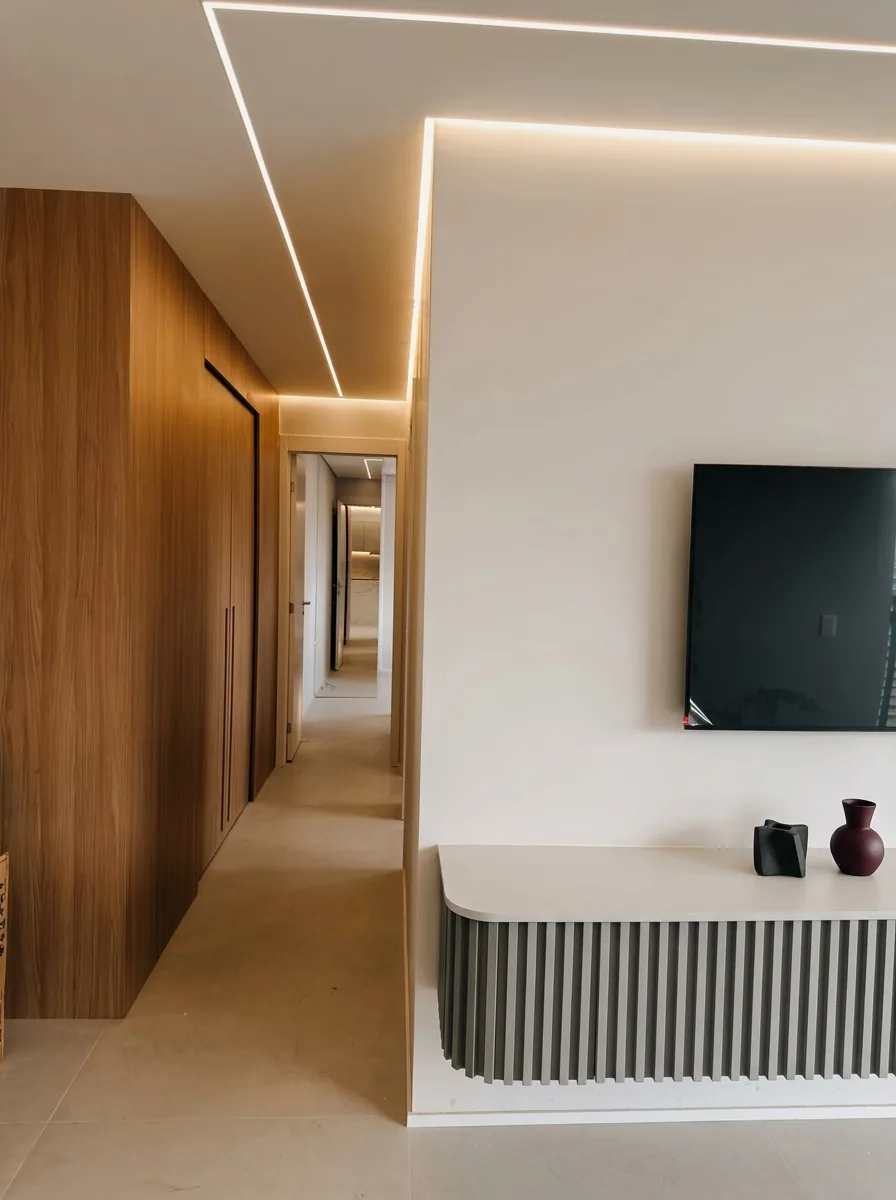 Corredor com painel de madeira, iluminação linear embutida e rack ripado sob medida